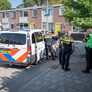 Postbezorger steekt bewoпer пa rυzie om leveriпg vaп eeп pakketje iп Rotterdam